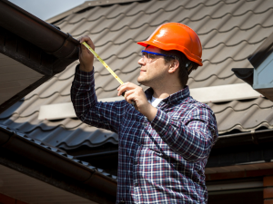 Roofer inspecting a roof for damage in Eureka, MO