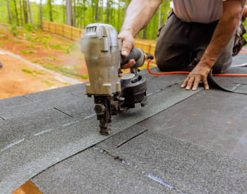 Professional roofer installing asphalt shingles